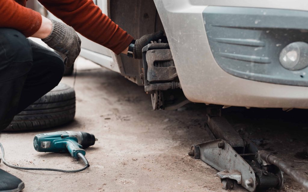 Easy DIY car repair, person repairing car tires and brakes.