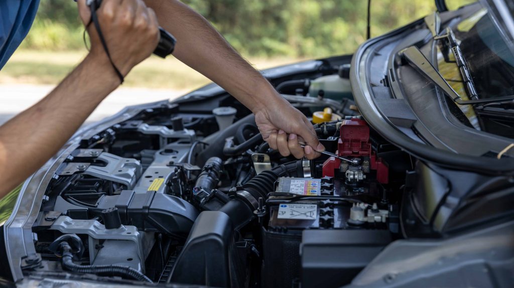 Easy DIY car repair, person checking car batteries.