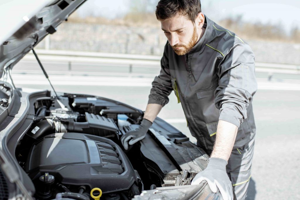 Car repair mistakes, man wearing safety gloves to check car engine.