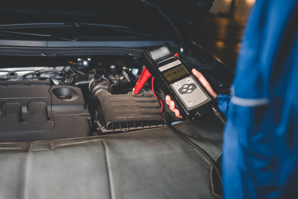 Car electrical system, person checking car battery status.