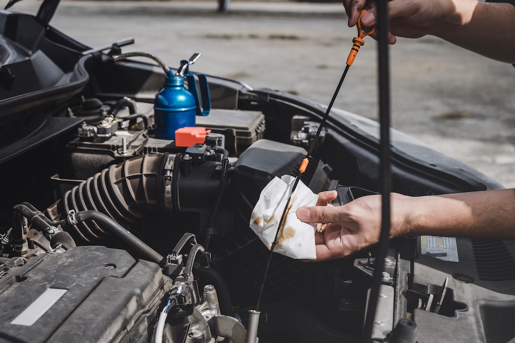 DIY car engine repair, person checking car engine oil.